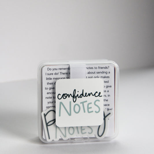 A small clear plastic box labeled "Confidence Notes" holds handwritten text and inspirational note cards inside.