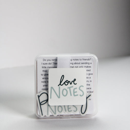 A small, transparent box contains several note cards that you can pass to your loved ones. "Love Notes," is elegantly written in cursive on the box, expressing that the theme of this box is Love themed.