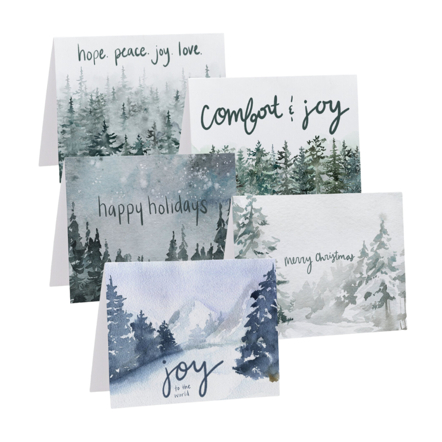A collective of festive printable holiday cards. Each design features festive sayings like "happy holidays" and "comfort and joy" and includes hand watercolor evergreen trees in a wintery snowy setting.