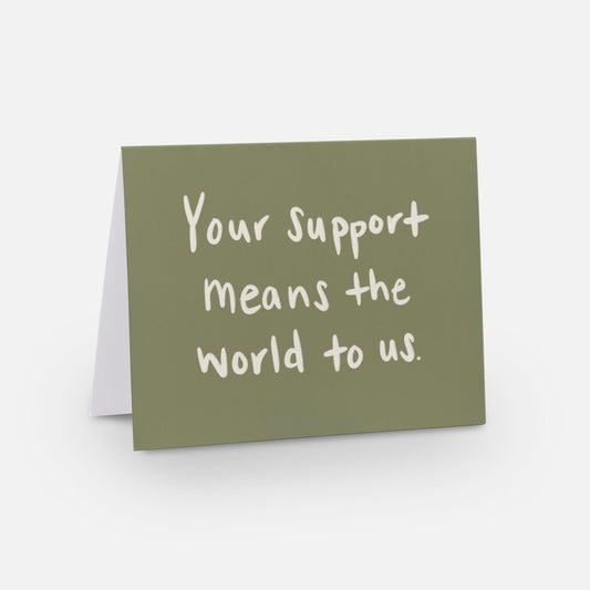 A2 horizontal sized card with a olive green background with a white handwritten font that says "your support means the world to us"
