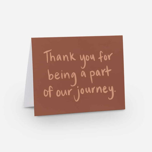 A2 horizontal sized card with a soft red background and light red handwritten font that says "thank you for being a part of our journey"