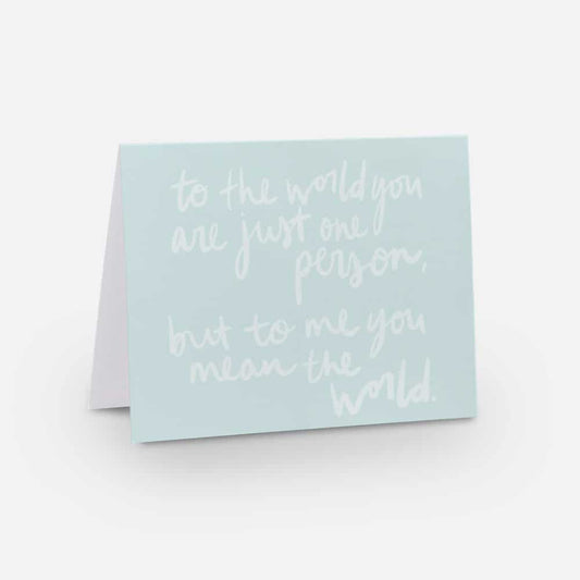 A2 horizontal sized card with light blue background and white handwritten font that says "to the world you are just one person, but to me you mean the world"
