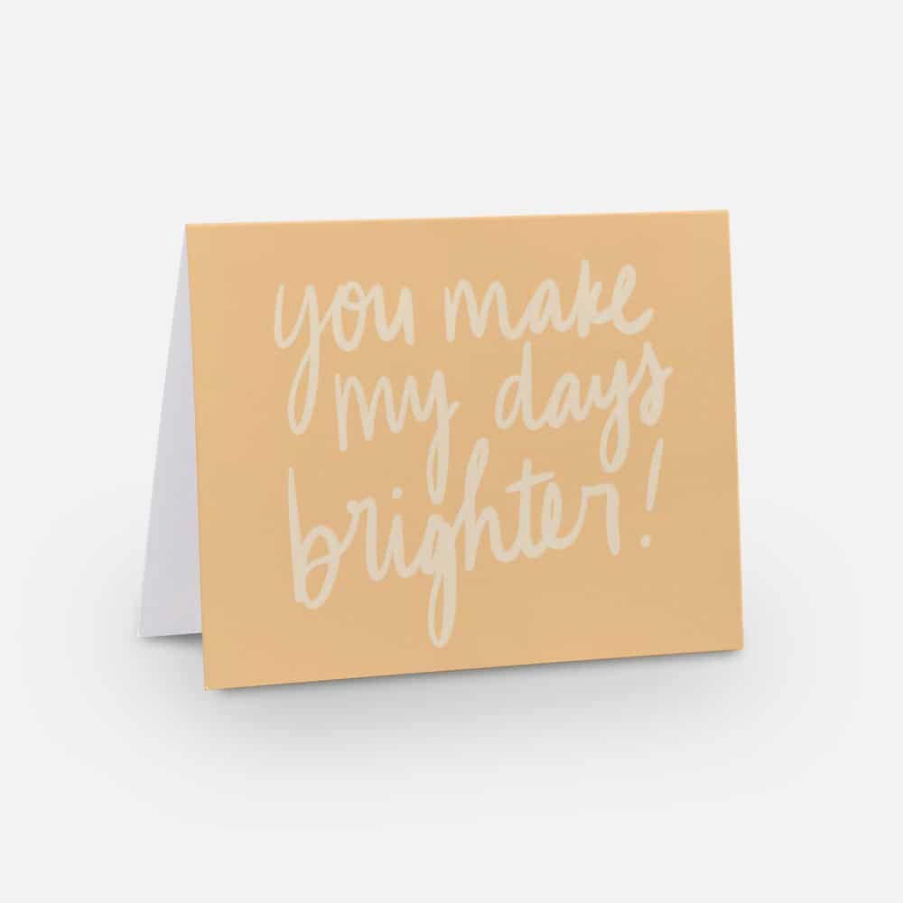 A2 sized horizontal you matter card with a golden yellow background and white font that says "you make my days brighter!" in handwritten font