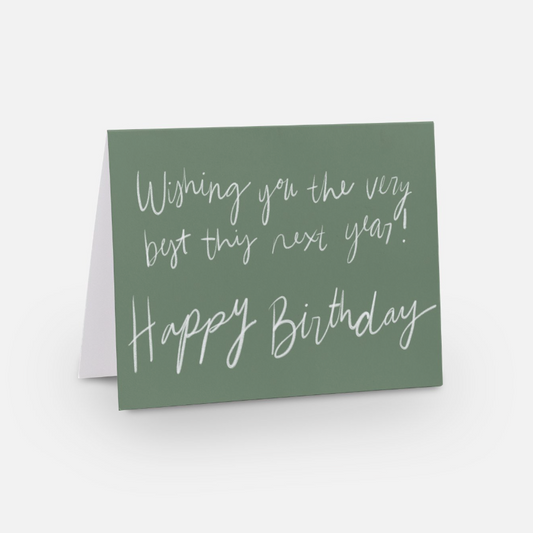 A2 sized horizontal card with a soft green background and white handwritten font that says "wishing you the very best this next year! Happy Birthday"