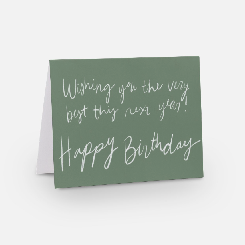 A2 sized horizontal best wishes card with a soft green background and white handwritten font that says "wishing you the very best this next year! Happy Birthday"