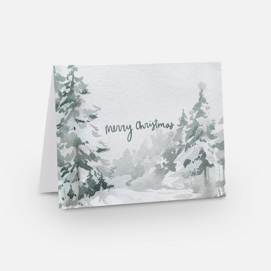 A Merry Christmas card bundle featuring a watercolor painting of snow-covered evergreen trees. The words "Merry Christmas" are written in elegant script across the center, encapsulating the holiday season's spirit. Each card is set against a plain, light background.